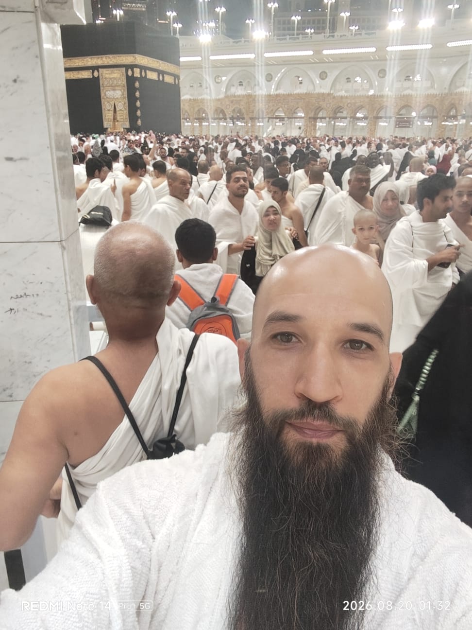 Pellegrino in ihram davanti alla Kaaba